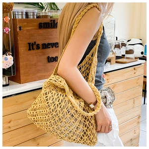 Close-up of yellow woven tote bag showing hollow mesh design and thick strap details