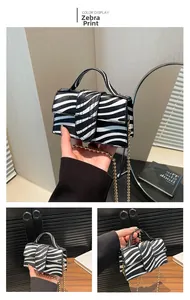 Dettaglio della mini borsa zebrata con catena a sfere dorate e texture in pelle PU