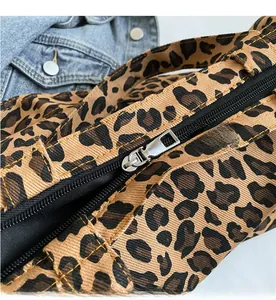 Close-up of leopard print canvas tote with high-quality silver metal zipper detail
