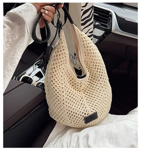 Close-up of hand-woven hollow mesh tote bag with black leather strap and brand label