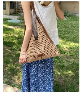 Scatto esterno di una modella con borsa a tracolla beige all'uncinetto e cinturini in pelle