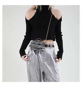 Close-up of zebra pattern mini bag with gold chain strap on stylish model outfit