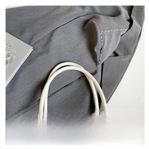 Detail of comfortable white leather double round handles on stylish rivet bow handbag