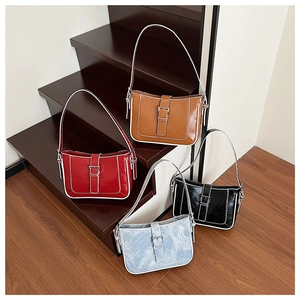 Detailed view of crescent shoulder bags in brown, red, black, and textured light blue
