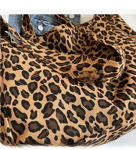 Close-up of leopard print canvas fabric texture and soft integrated handle strap