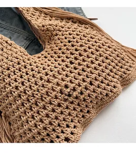 Detail showing the intricate openwork weaving process and soft fringe of the beach tote