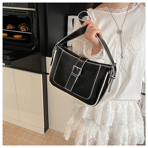 Detail of black leather crescent bag with white contrast stitching and silver buckle