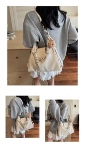 Details der cremefarbenen Beuteltasche mit Silberkette und braunem Plüschbär-Anhänger