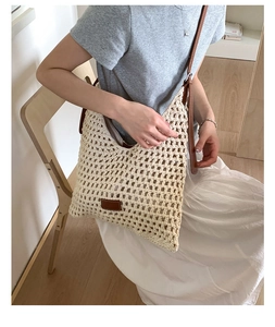 Dettaglio della trama intrecciata e logo in pelle sulla borsa a tracolla in crochet