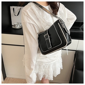 Detail of retro black shoulder bag with white piping and silver buckle on flap