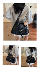 Detailansicht der schwarzen Tasche mit Wolkentextur, Modeschriftzug und Bärenanhänger