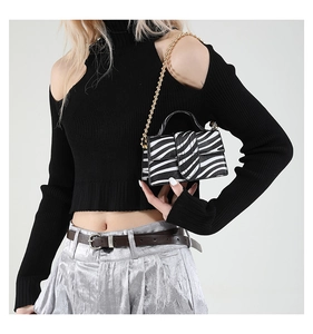 Zebra pattern crossbody bag with gold chain strap shown on model with black knitwear