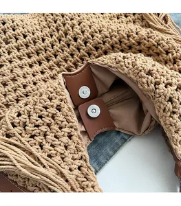 Detail of woven straw tote showing magnetic snap closure, lining, and internal zip pocket