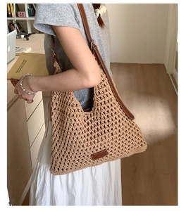 Dettaglio della trama intrecciata e del logo in pelle di questa grande borsa a tracolla