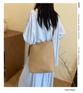 Detail of minimalist beige leather shoulder bag with fine texture and slim strap