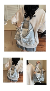 Silbergrauer Rucksack aus Kunstleder mit Wolkentextur und braunem Plüschbär-Anhänger