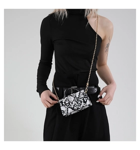 Close-up of stylish snake pattern crossbody bag with golden chain and top handle strap