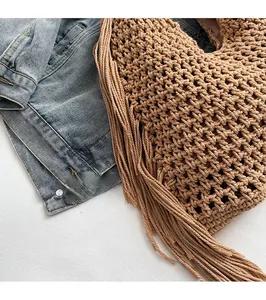 Detail of khaki handmade woven tote bag with hollow mesh pattern and long side fringe