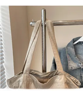 Detail of beige large capacity tote bag featuring pleated fabric and durable shoulder straps