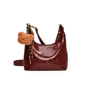 Glossy burgundy hobo bag in polished leather with bear charm and golden buckle detail