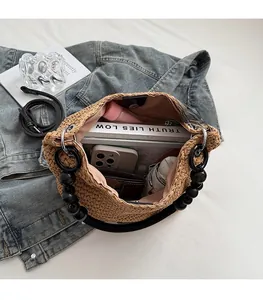 Detail view of woven straw shoulder bag interior showing large capacity and zipper pocket