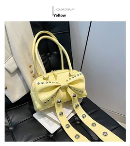 Close-up of yellow leather tote featuring oversized bow and silver metal rivet details