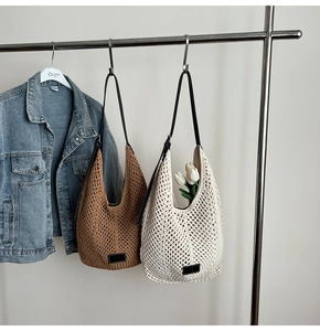 Vue détaillée de grands sacs en paille tissés à la main en marron et beige