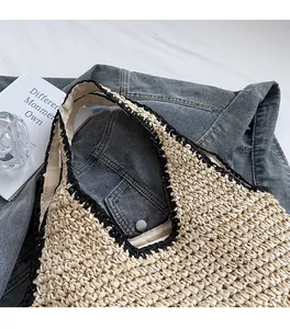 Close-up of woven shoulder bag with black crochet trim and beige straw texture