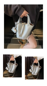 Detailed view of silver lychee leather bucket bag with lock and heart charm detail