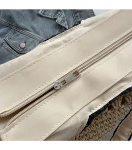 Close-up of smooth silver metal zipper and canvas edge on woven straw tote bag