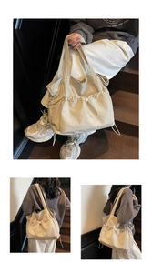 Detail of beige large tote bag with unique drawstring pocket and soft nylon texture