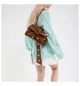 Brown faux leather shoulder bag with a large bow and silver rivet details on the strap