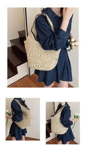 Detail of hollow-out woven pattern and black trim on beige straw shoulder tote bag