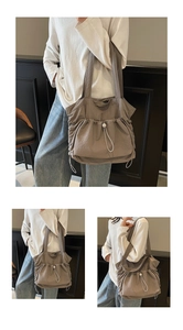 Detail of grey nylon tote bag showing drawstring pleats and adjustable shoulder strap