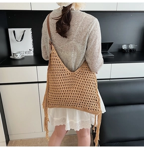 Detail of light brown hollow knit tote bag with fringe tassels and leather shoulder strap