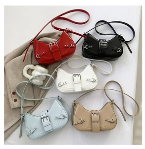 Five crescent shoulder bags in red, black, white, blue, and beige with buckle details
