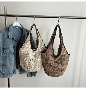 Detailed shot of woven straw shoulder bags in cream and coffee colors for beach vacations
