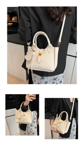 Détail du sac seau en cuir grainé blanc crème avec logo PAN TOR et fermoir doré