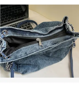 Detail of smooth metal zipper and silver chain strap on retro denim tote bag