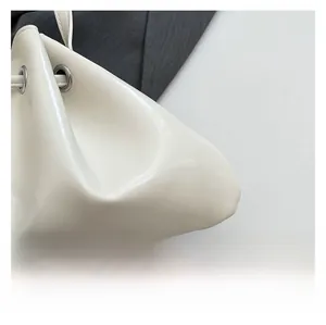 Detail of white drawstring bucket bag showing silver metal eyelets and premium texture