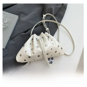 White rivet bucket bag detail with drawstring closure and phone for size reference