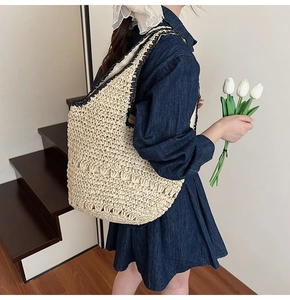 Detail of cream woven shoulder bag with black trim and hollow diamond pattern texture