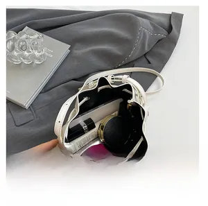 Internal capacity of the minimalist bucket bag showing phone and cosmetics