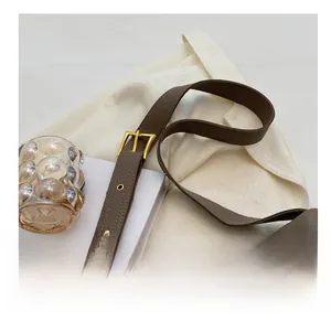 Detail of brown lychee grain leather shoulder strap with gold metal buckle and eyelets