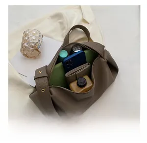 Deep khaki pebbled leather shoulder bag showing large interior capacity for daily essentials