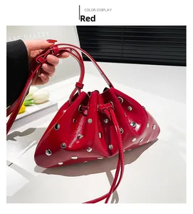 Detail of red bucket bag with metallic silver rivets and glossy patent leather finish