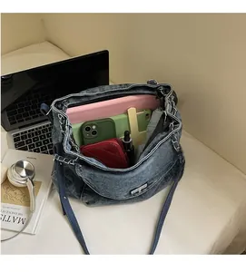 Detail of spacious denim tote bag interior showing capacity for tablet and daily essentials