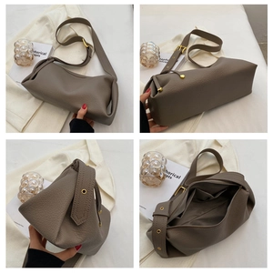 Detail view of earth-tone lychee pattern crossbody bag with wide strap and gold hardware