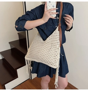 Detail of hand-woven cream tote with cotton mesh texture and fringe tassels