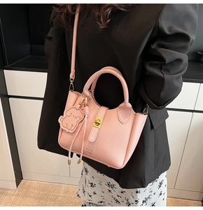 Sac seau rose à grain litchi avec fermoir pivotant doré et breloque petit chien
